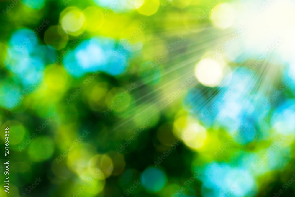 Summer abstract bokeh background in green yellow and blue colors with sun rays. Blurred background of green leaves on nature. Summer abstract bokeh background in green yellow and blue colors with sun rays. Blurred background of green leaves on nature.