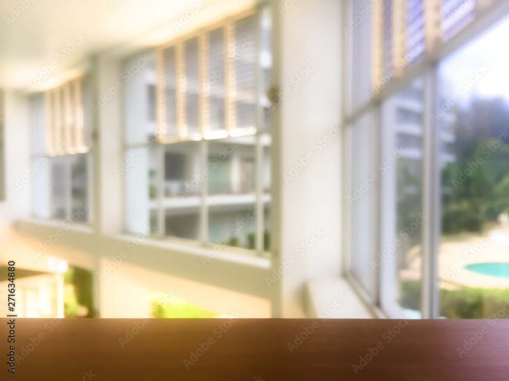 Empty wooden railing with blurred window and light background.