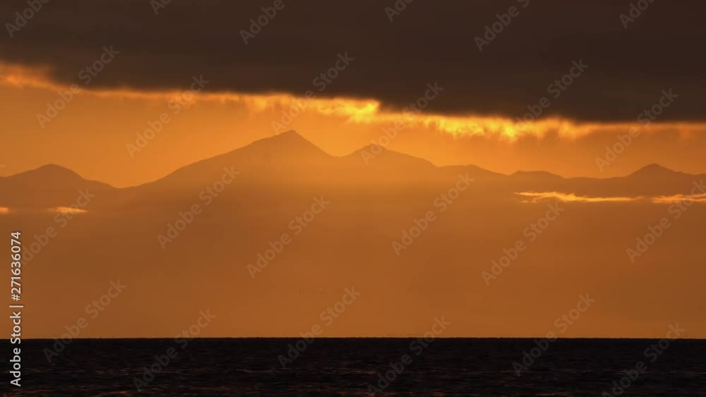 Stunning seascape - dramatic clouds illuminated by rays of sun, floating across sky to weather change. Travel destinations, Pacific Ocean and mountains landscape on shore of sea. Dramatic time lapse Stunning seascape - dramatic clouds illuminated by rays of sun, floating across sky to weather change. Travel destinations, Pacific Ocean and mountains landscape on shore of sea. Dramatic time lapse