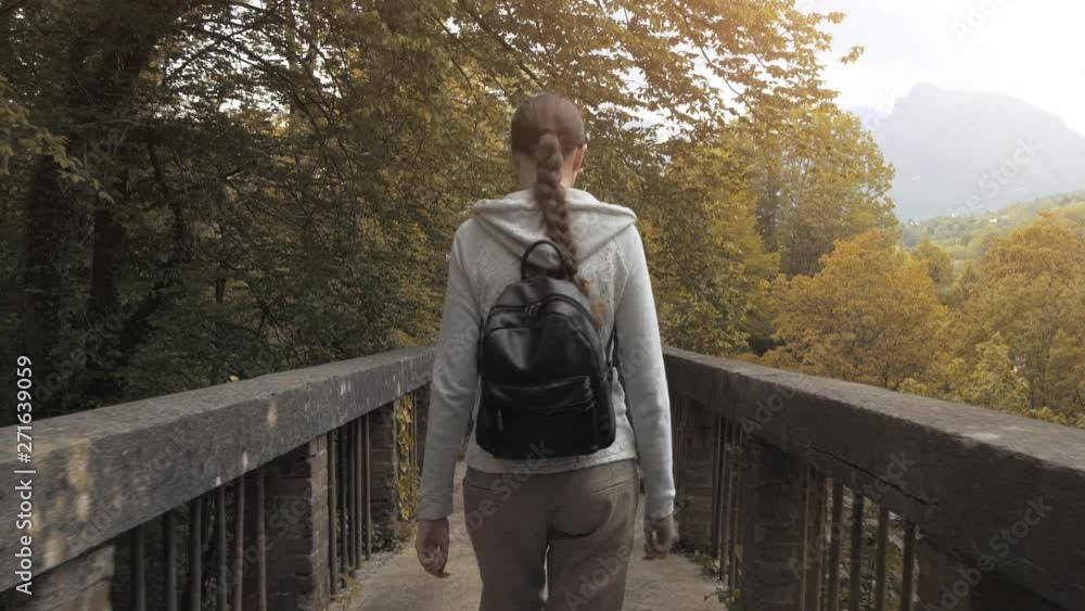 Young woman walking on a footbdridge in nature Young woman walking on a footbdridge in nature
