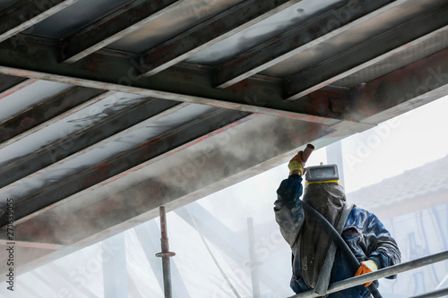 Fotografie Sand blasting process  Industial worker using sand blasting process preparation