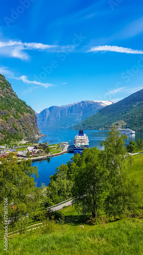 A view on port located at the Sognefjord, Norway. Fjord goes far inland. A little street running along the shore. Small village located along the coastal line. Clear and beautiful day.