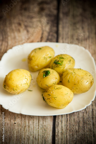 boiled young potato with butter and dill in a plate