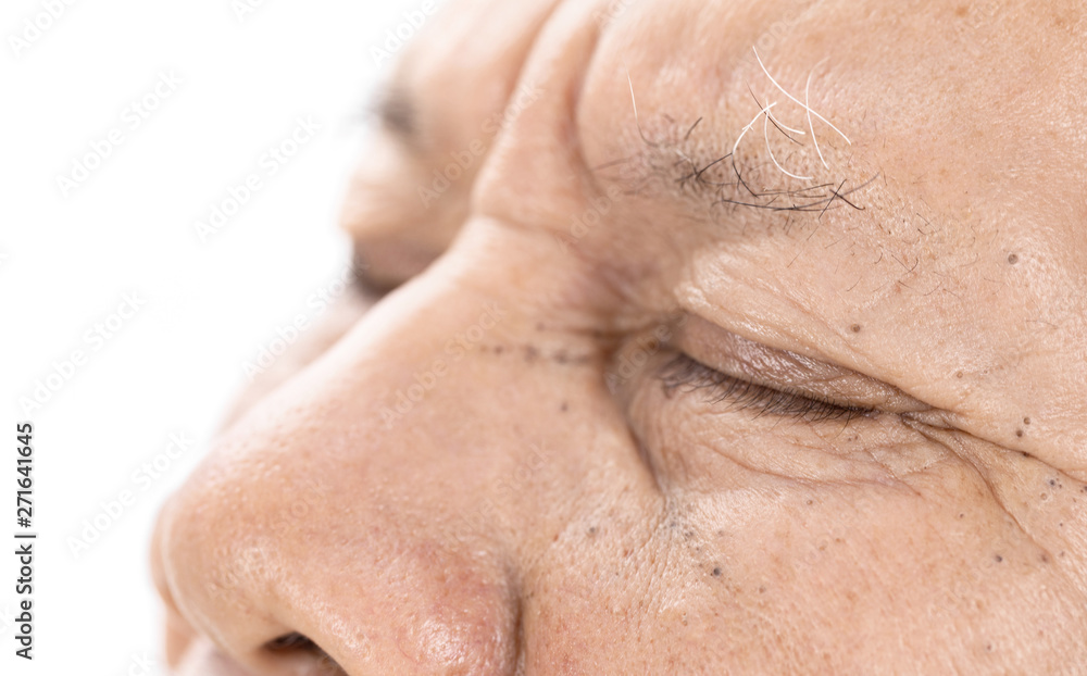 Naklejka premium close-up of elderly asian man eyes with wrinkle on face