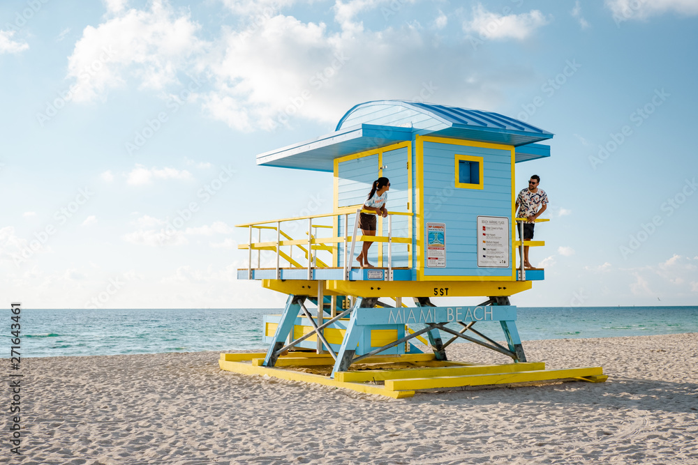 Obraz premium Miami south Beach, youn couple men and woman on the beach during sunrise. Miami beach Floarida