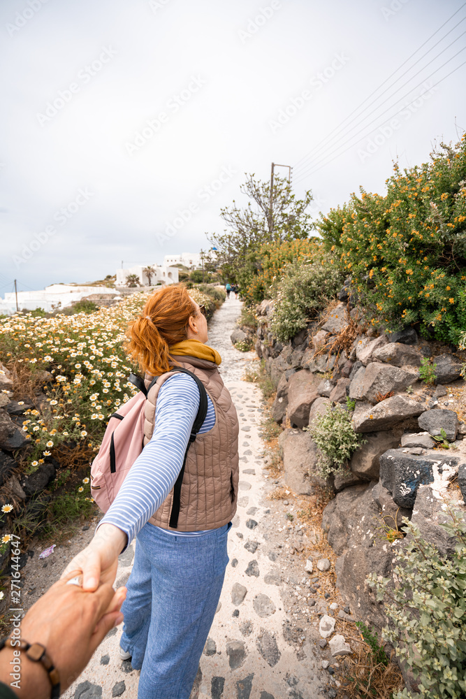 Naklejka premium Couple Traveling. Woman holding hand with Man and leading the Way to New Places