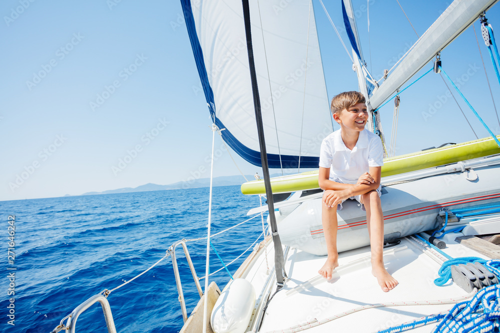 Obraz premium Little boy on board of sailing yacht on summer cruise. Travel adventure, yachting with child on family vacation.