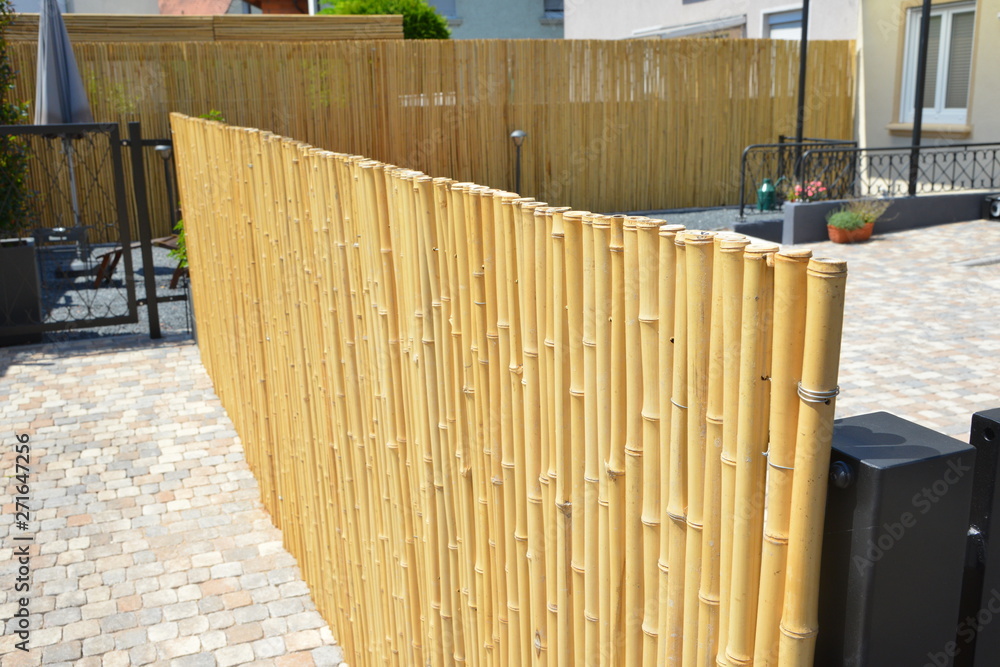 Moderner Sichtschutzzaun aus Bambusstangen um einen um einen neu