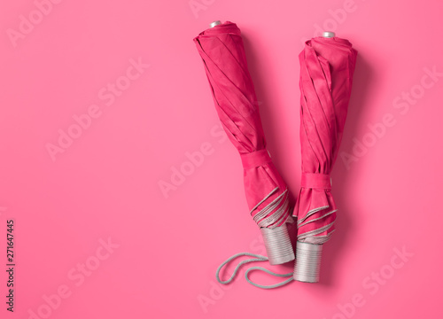 Pink umbrella on blue color background with space for design,top view