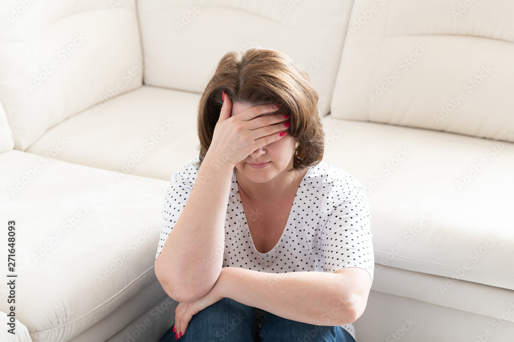 Depressed woman covering her face with her hands Depressed woman covering her face with her hands