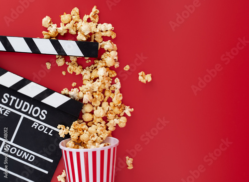 Clapper board with popcorn against red background,Cinema minimal concept,top,view photo