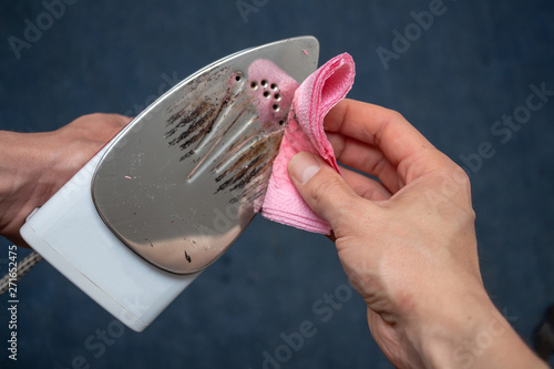 Removal of melted fibers and scrap hardened plastic on the soleplate. Cleaning the surface of the iron. Prevention of the soleplate surface from becoming scratched or corroded. Household concept photo