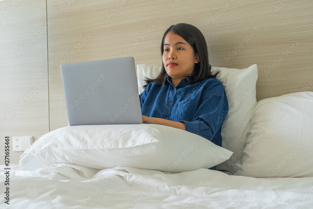 Young woman put laptop on pillow and working Young woman put laptop on pillow and working