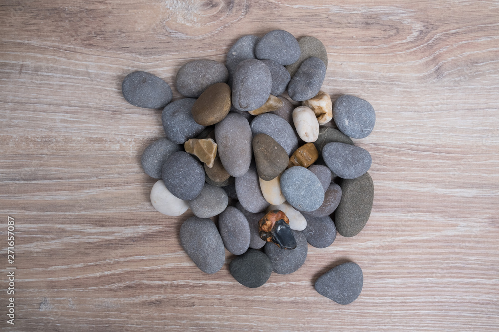 Fototapeta premium A bunch of sea stones. River stones on a wooden background. Smooth stones.