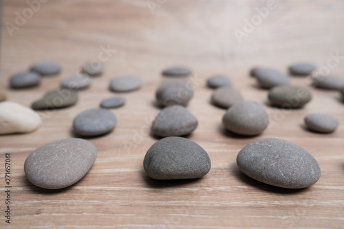 Sea stones arranged in rows. River stones on a wooden background. Smooth stones.