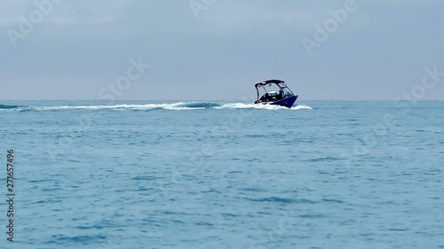 Motor boat sailing on wavy blue sea water. Speed nautical vessel