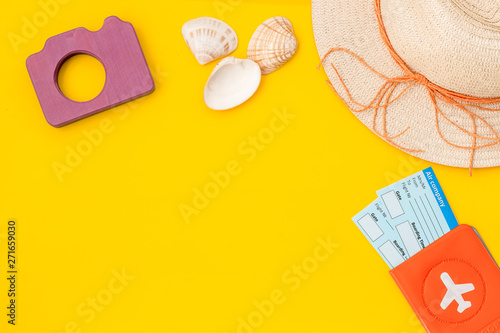 Funny vocation concept with camera, hat, passport and tickets on yellow background top view space for text