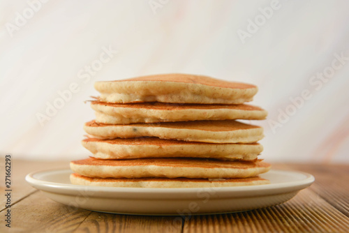 Stack of pancakes on wooden background. Homemade american pancakes, isolated.
