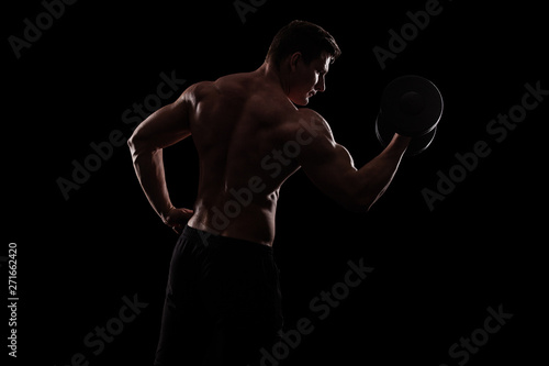 Bodybuilding competitions on the scene. Man sportsmen physique and athlete. Black background with lights. © Mike Orlov