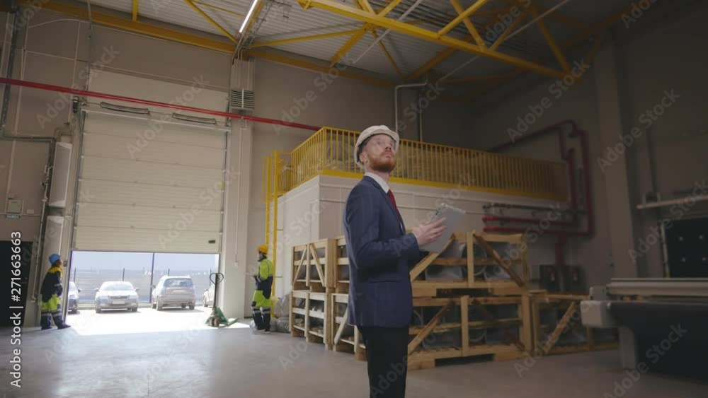 Engineer in hard hat uses touchscreen tablet Engineer in hard hat uses touchscreen tablet