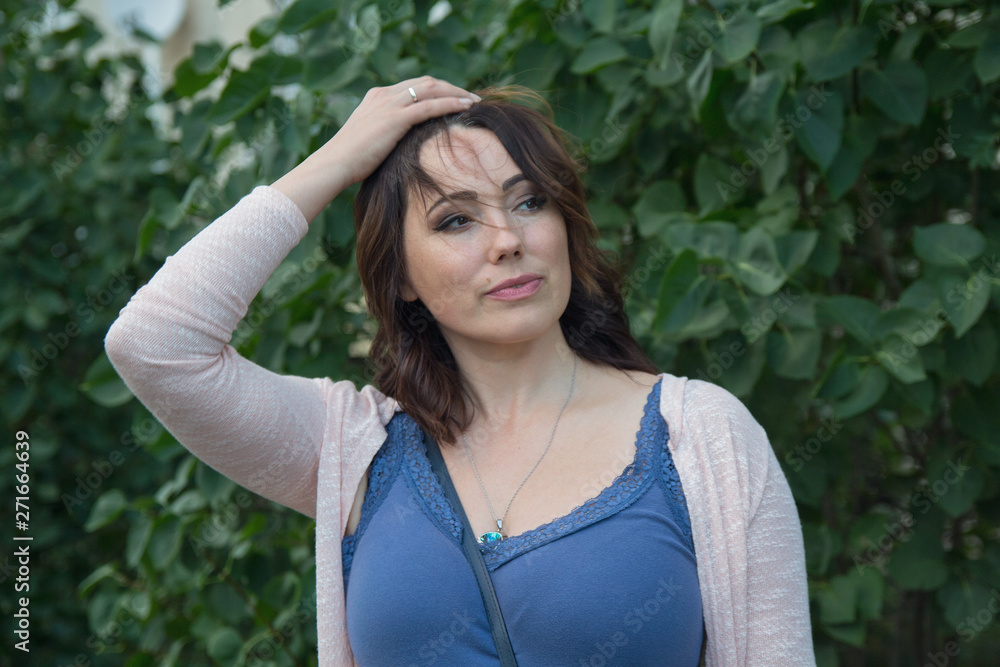 Serious simpotichnaya woman in the garden. People Serious simpotichnaya woman in the garden. People
