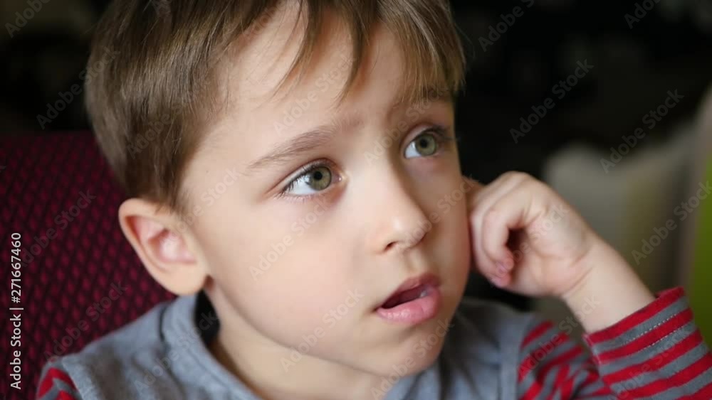 Portrait of a pensive boy who holds his hand to his ear Portrait of a pensive boy who holds his hand to his ear