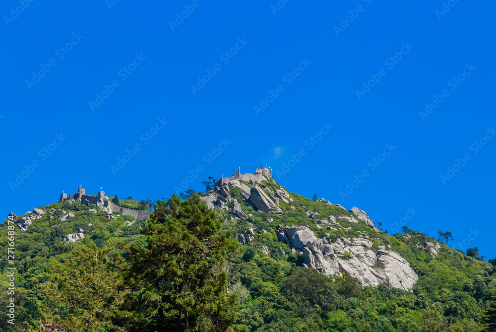 The Castle of the Moors is a hilltop medieval castle in Sintra. View of the castle from Quinta da Regaleira.. Portugal The Castle of the Moors is a hilltop medieval castle in Sintra. View of the castle from Quinta da Regaleira.. Portugal