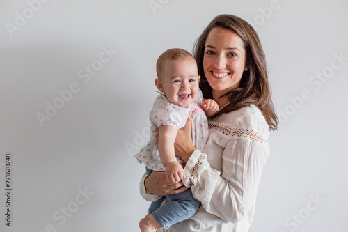 portrait of a beautiful baby girl and her mother at home. Family concept indoors. Daytime and lifestyle
