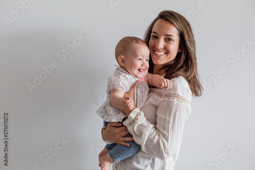 portrait of a beautiful baby girl and her mother at home. Family concept indoors. Daytime and lifestyle