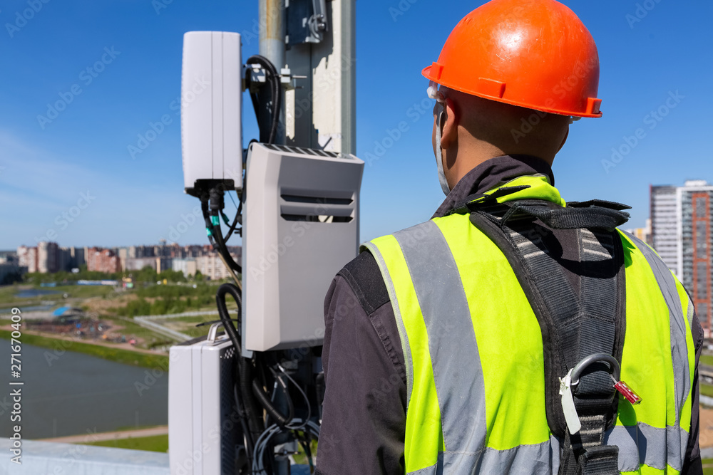 Telelecom Engineer Telecommunication engineer in helmet and uniform holds telecomunication ...