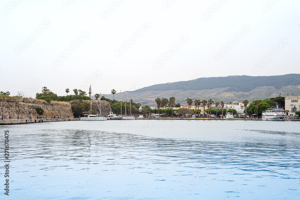 The scenic port with traditional views of the city, palm trees and boats in the village , Kos island, Greece