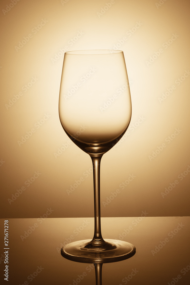 an elegant empty glass of wine is standing opposite the light an elegant empty glass of wine is standing opposite the light