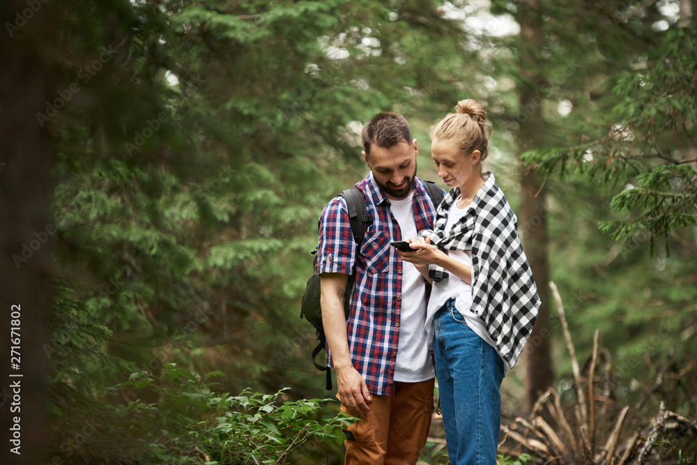 Couple with smart phone in the forest
