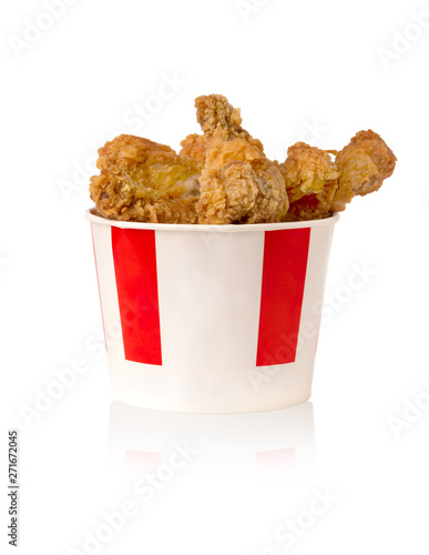 Fried legs and wings on a white background. Chicken wings and legs deep-fried in a cardboard bucket.