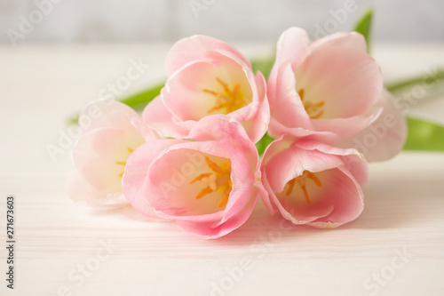 bouquet of gently pink tulips on white wooden table. Thin petals of tulip flowers with stamens and peaches  group of pink flowers  postcard background close-up