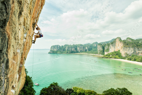 Thailand, Krabi, Thaiwand wall, woman climbing in rock wall above the sea photo