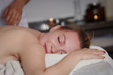Blond European girl is having relaxing massage procedure in a spa salon.