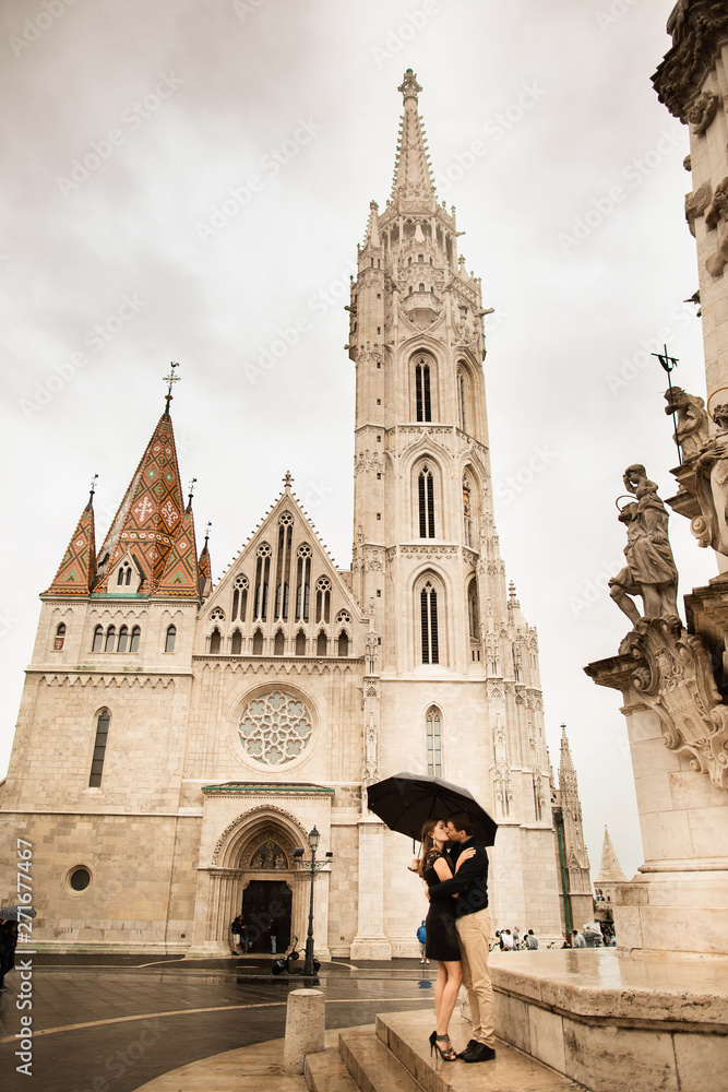 Hugged loving couple by the Fisherman's Bastion in Budapest, Hungary on a rainy day