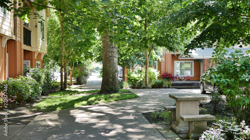 A peaceful condo apartment neighborhood setting with trees and sidewalk.
