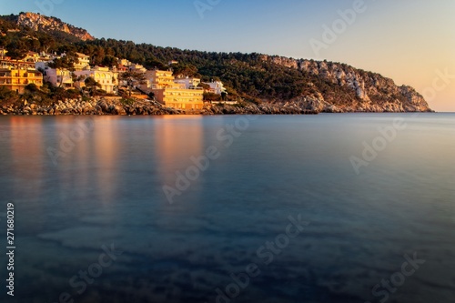 Sant Elm coastline, sunset,mediterranean sea, clear blue water,rocks, golden sunlight, hills, trees, near Sa Dragonera nature park, Malorca, Spain.
