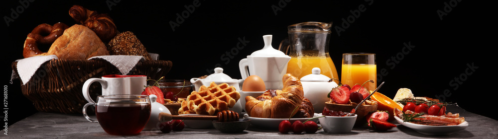 Huge healthy breakfast on table with coffee, orange juice, fruits, waffles and croissants. Good morning concept. Huge healthy breakfast on table with coffee, orange juice, fruits, waffles and croissants. Good morning concept.