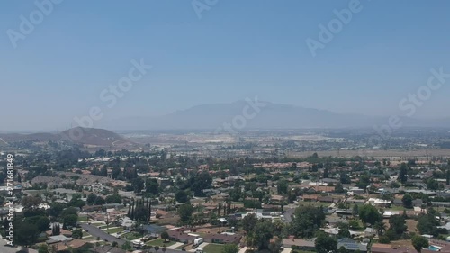 Aerial view of suburban neighborhood and mountain in daylight.