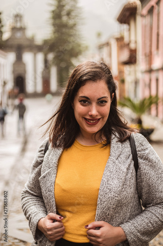 Happy hispanic woman smiling with mustard jumper