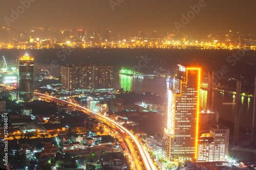 Aerial view of Bangkok downtown buildings and Chao Phraya River at night.