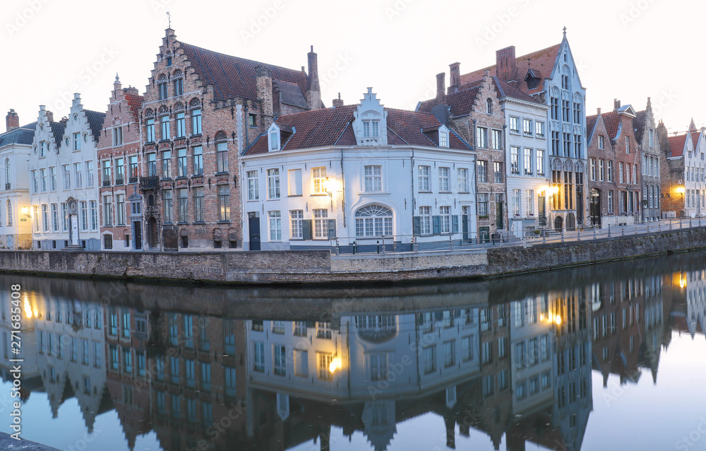 Scenic city view of Bruges canal with beautiful medieval colored houses and reflections in the evening.