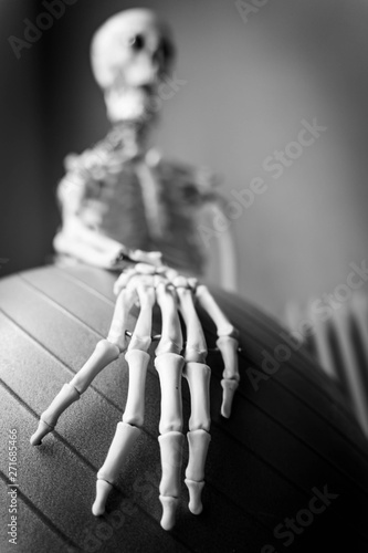 Blurred human skeleton holding a fitness ball (black and white)