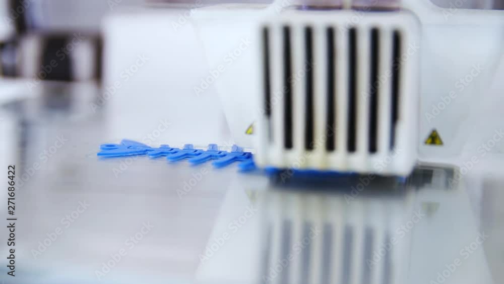 3D printing process close-up 4K. Static shot of a product in focus while the printer head moves over making layers.