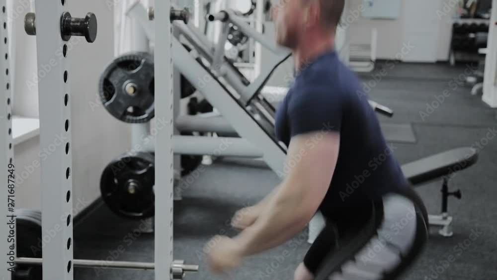Athletic man performs speed squats in the gym. Athletic man performs speed squats in the gym.