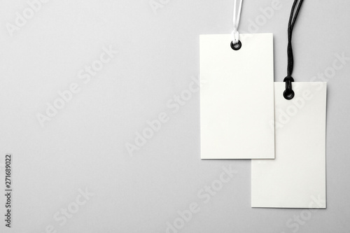 Cardboard tags with space for text on light background, flat lay