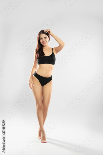 Full length portrait of attractive young woman with slim body in swimwear on white background © New Africa